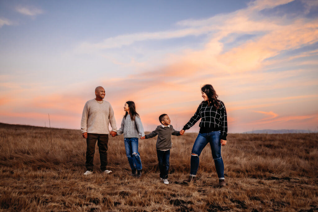 A sunsets behind a family of 4, happy they chose to have family photos taken of their growing family.