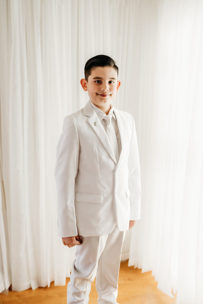 boy in white suit for first communion photos