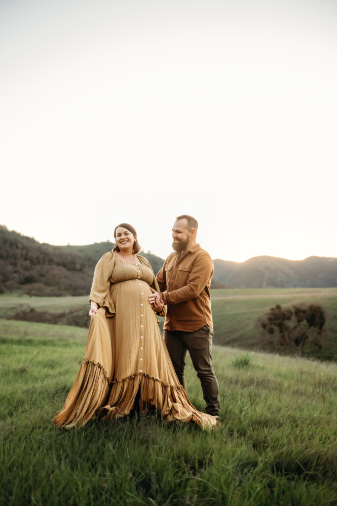 couple laughing during their maternity session.