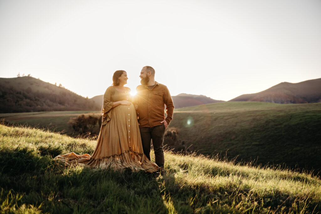 sunlight peeks through a couple during their photoshoot at mt diablo. you see the peak towards the left