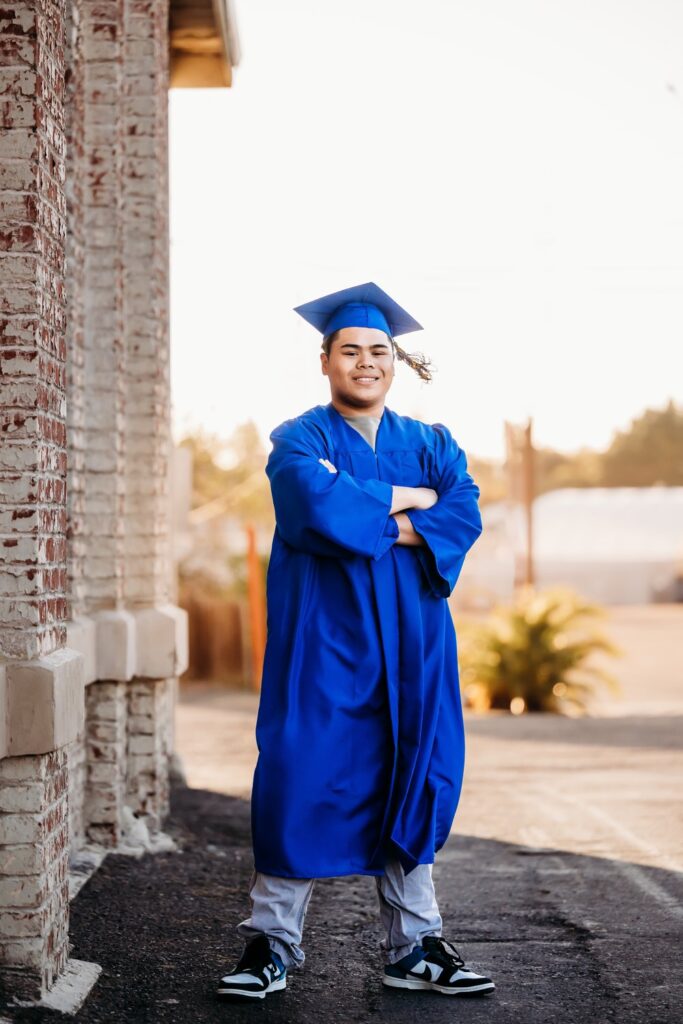 Boy wearing cap and gown in industrial area of Benicia