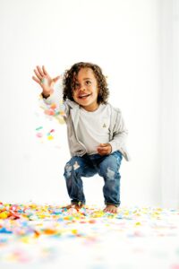 boy drops rainbow confetti