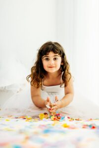 little girl looks at camera before tossing confetti