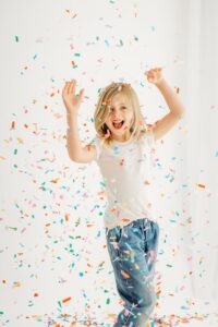 girl dancing in falling confetti