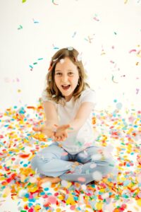 child catches falling confetti
