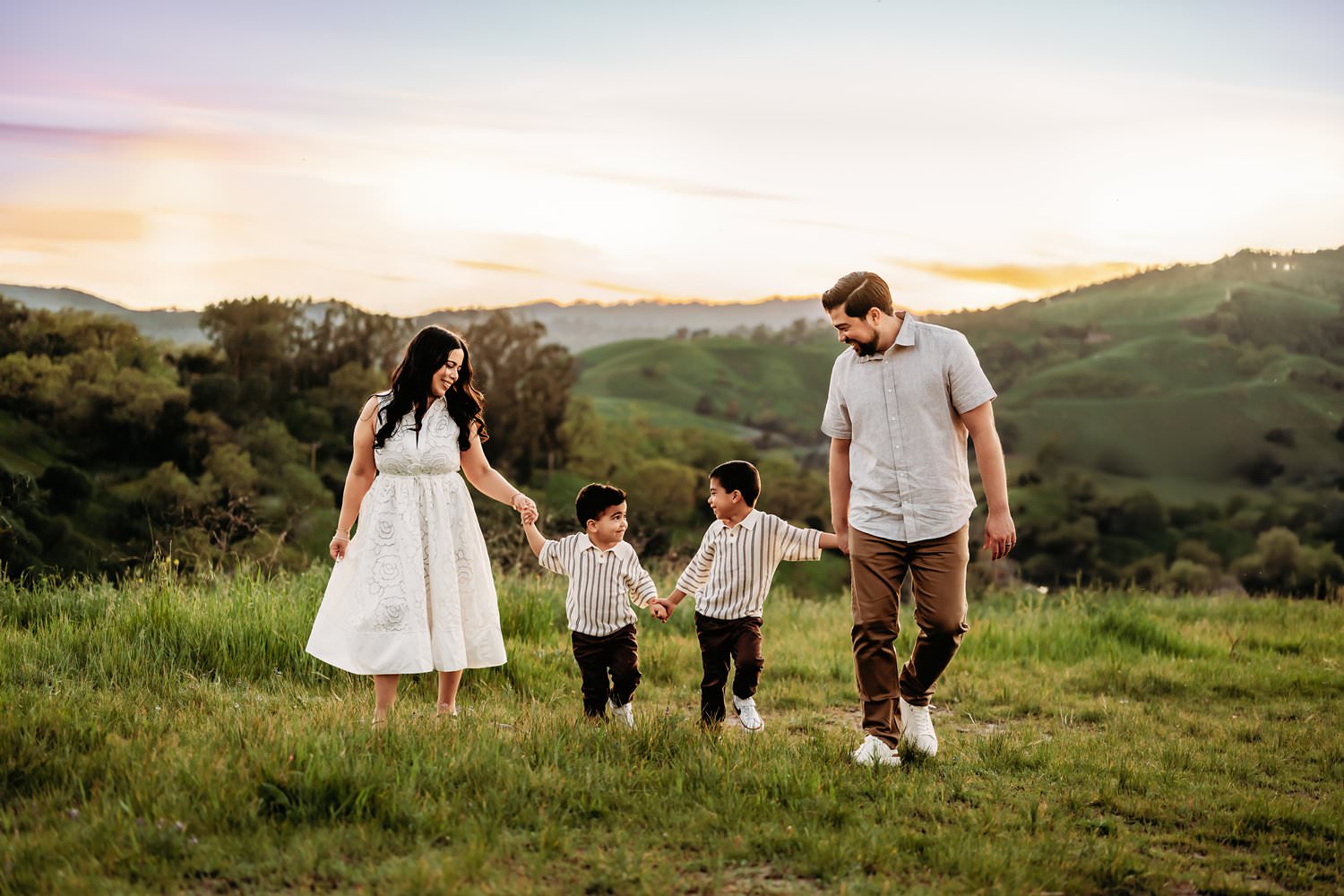 family of 4 walking in a line at the end of their photoshoot. the lafayette hills are seen behind them.
