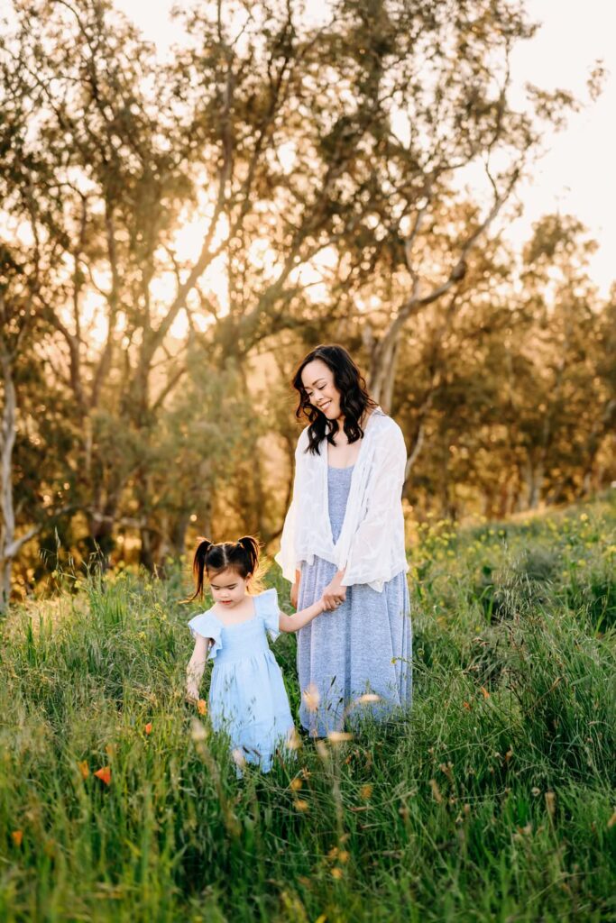toddler girl holds moms hand, leading her through the field of flowers in lafayette
