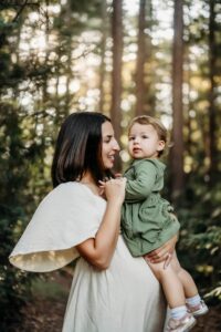 pregnant mom holds her toddler in a redwood forest
