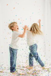 kids yell and dance in falling confetti