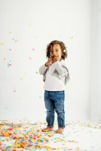 toddler looks at camera after dropping confetti