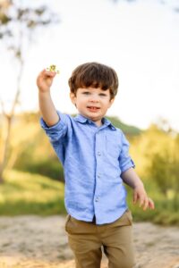 boy shows camera his mustard flower proudly