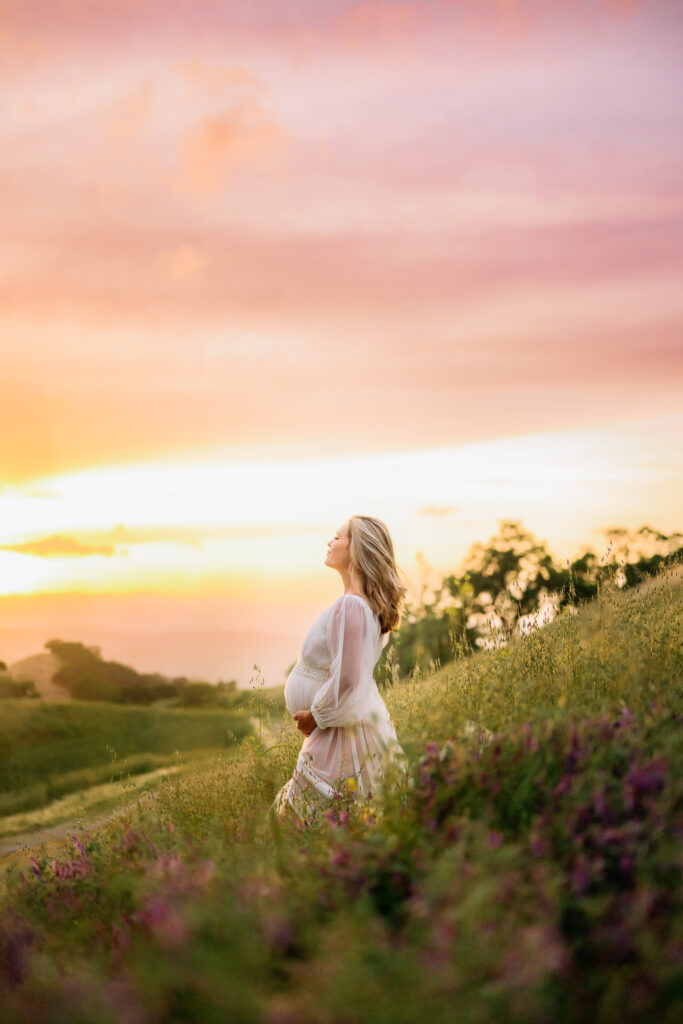 mom with eyes closed holding her baby bump surrounded by walnut creek flowers
