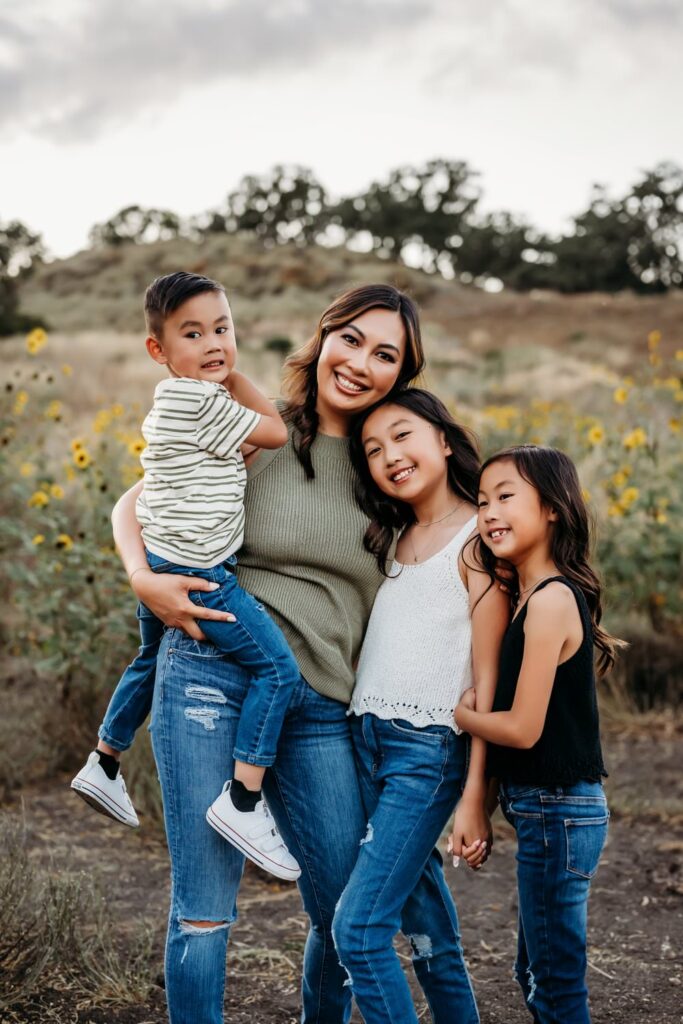 mama and her 3 kids look at the camera and smile