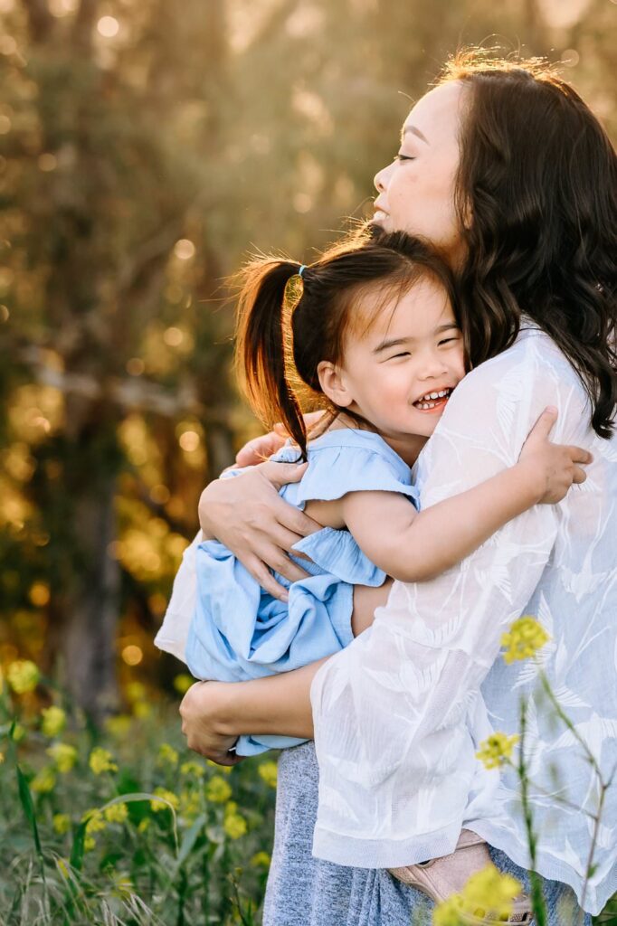 toddler hugs mom in a field of wildflowers in lafayette ca