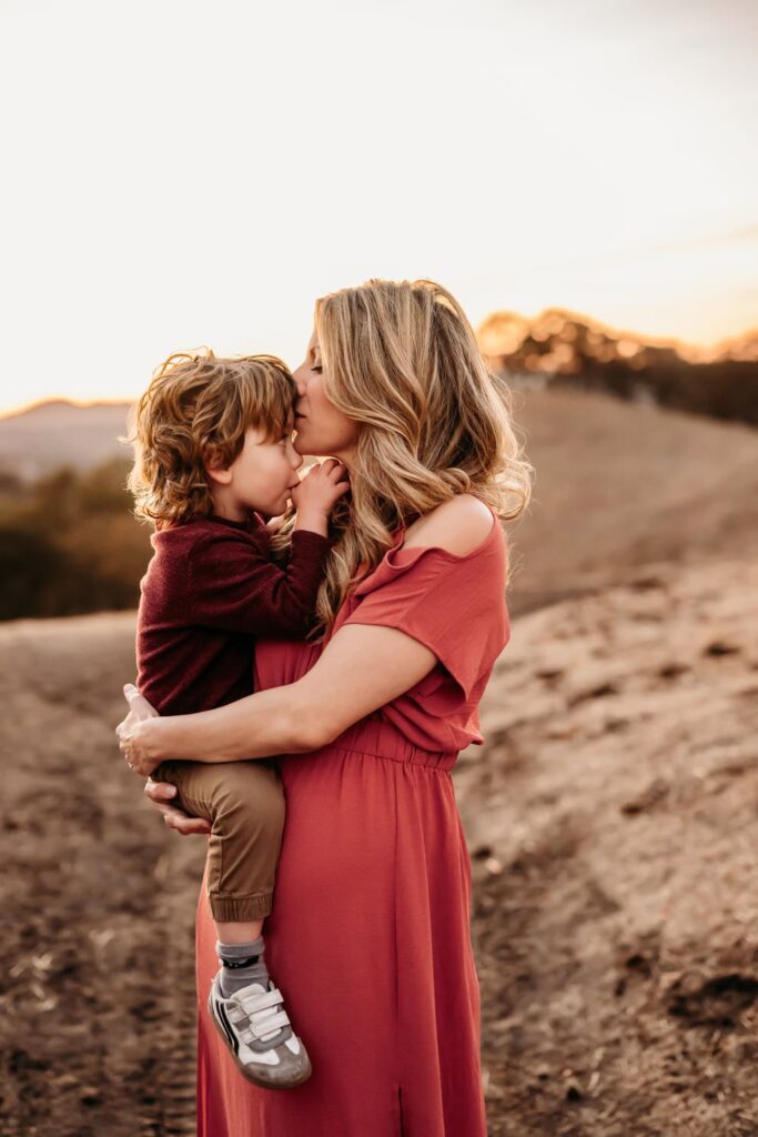 cute toddler looks up of his mama during their photoshoot