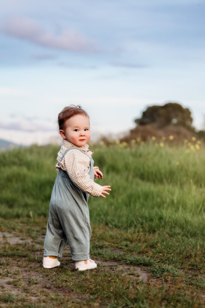 baby looks over shoulder towards camera