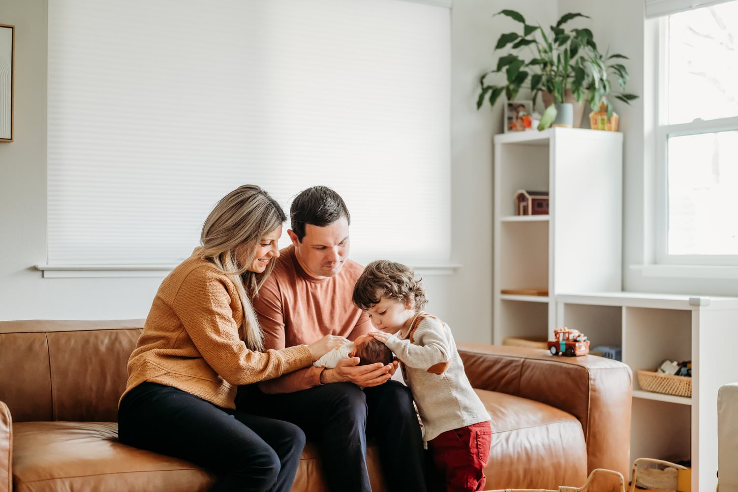 big brother peeks at baby sister during newborn photos in their lafayette ca home